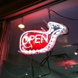 a neon open sign in a shop window
