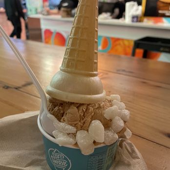 Soft Swerve - Hong Kong milk tea - A cup of soft serve ice cream topped with a cone, surrounded by white candy pieces, served at Soft Swerve in Brooklyn, NY. - Ice Cream & Frozen Yogurt Near Me - Brooklyn, New York