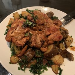 Pan-seared chicken thighs over crispy kale and potatoes