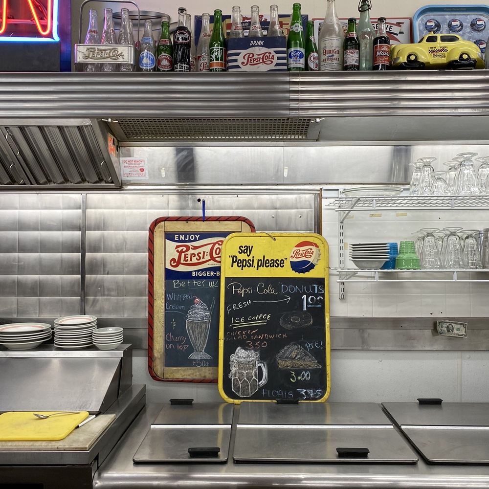 Laconia Antique Center - Antique soda bottles above the lunch counter with current menus on display - Antiques Near Me - Laconia, New Hampshire