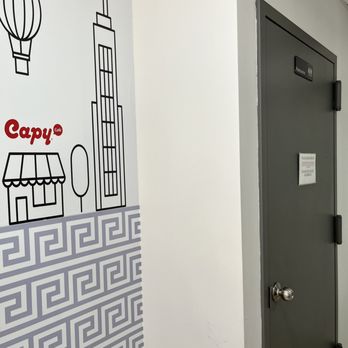Capy - a hallway with a door and a sign on the wall - Bakeries Near Me - New York, New York