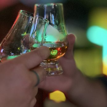 Roam - Friends toasting some whiskey - Cocktail Bars Near Me - Seattle, Washington