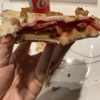 Murray's Pizza - a hand holding a half eaten pizza - Pizza Near Me - Kelowna, British Columbia Murray's Pizza - a hand holding a half eaten pizza - Pizza Near Me - Kelowna, British Columbia