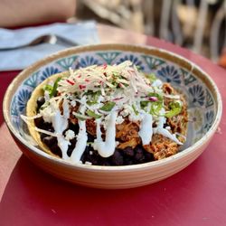 The Taco Project - Chicken Burrito Bowl - a crisp flour tortilla shell topped with chicken, rice, beans, queso fresco, cheese, sour cream, radish, and cilantro