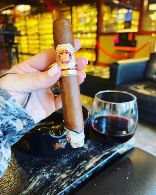 Photo of Casablanca Cigar Bar - Asheville, NC, US. Arturo Fuente cigar and glass of Pinot noir.