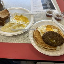 The Wilton Grill - Two sunnyside up egg breakfast with one egg over grits and one over two butter milk pancakes and sauage.