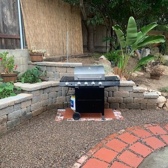 JH Landscaping & Construction - Was a dirt hill. Now a beautiful curved retaining wall with flat area for grill, and vegetable planters. - Landscaping Near Me