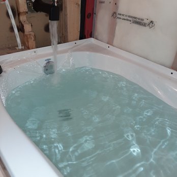 Build Brothers - a bathtub with water running from the faucet - Handyman Near Me Build Brothers - a bathtub with water running from the faucet - Handyman Near Me