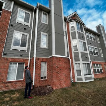 Ace GC Exteriors - a man standing in front of an apartment building - General Contractors Near Me Ace GC Exteriors - a man standing in front of an apartment building - General Contractors Near Me