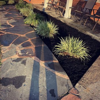 Goldsmith Landscaping - a stone walkway with plants and chairs - Landscaping Near Me