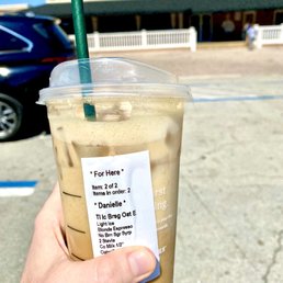 a hand holding a cup of iced coffee a hand holding a cup of iced coffee