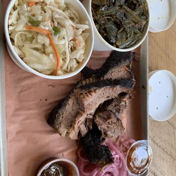 Handsome Devil - 1/4 lb fatty brisket, coleslaw, collard greens w/ham hock meat, bbq sauce, and pickles onions. - A meal featuring smoked barbecue ribs, coleslaw, cooked greens, and pickled onions, served with barbecue sauce in small containers. - Barbeque Near Me - Poughkeepsie, New York