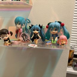 The figurine in the center is the one that I bought in a blind box. Note the poor proportions and low-quality face.