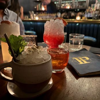 Patent Pending - a man sitting at a table with drinks - Speakeasies Near Me - New York, New York Patent Pending - a man sitting at a table with drinks - Speakeasies Near Me - New York, New York
