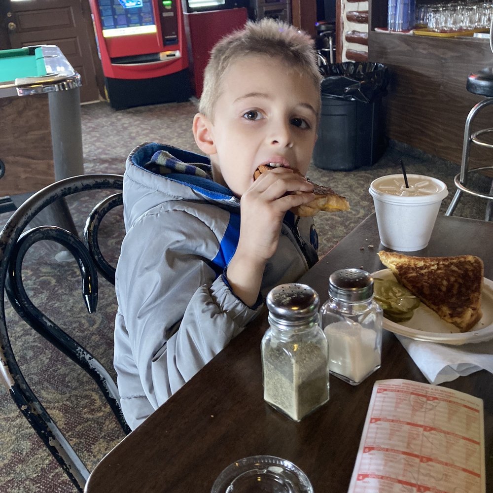 Talley's Log Cabin - The boy enjoying his grilled cheese. - Dive Bars Near Me - Lewiston, Michigan Talley's Log Cabin - The boy enjoying his grilled cheese. - Dive Bars Near Me - Lewiston, Michigan