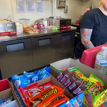 Boondoggies - a man in a kitchen with a box of snacks - Hot Dogs Near Me - Brentwood, California Boondoggies - a man in a kitchen with a box of snacks - Hot Dogs Near Me - Brentwood, California