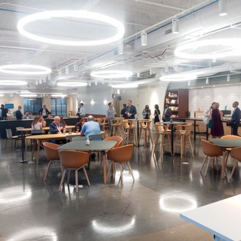 Convene - A spacious, contemporary lounge or cafeteria with seating, tables, and a bar area, filled with people engaging in conversations and working. - Venues & Event Spaces Near Me - Chicago, Illinois