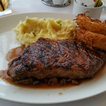 Peohe's - NY Steak dinner. Perfect Med-well sitting on a bed of mushrooms, buttery garlic mashed potatoes and coconut crispy onion rings. - Seafood Near Me - Coronado, California
