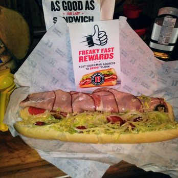 Jimmy Johns - a hot dog with toppings and a sign - Sandwiches Near Me - Jeffersonville, Indiana
