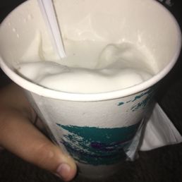 a hand holding a cup of yogurt