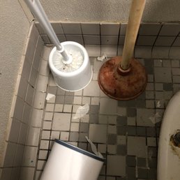 Toilet brush and plunger covered in poop next to the toilet Toilet brush and plunger covered in poop next to the toilet