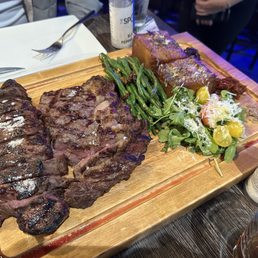 Strip steak and a rib-eye done medium rare with sides including some truly amazing potatoes. Strip steak and a rib-eye done medium rare with sides including some truly amazing potatoes.