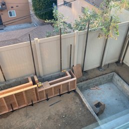 Progress on the fence, hot tub area, and the planter walls with a floating bench.
