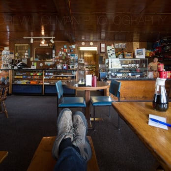 Tangle River Inn - a man sitting at a table with a bottle of wine - Hotels Near Me - Delta Junction, Alaska