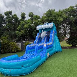 Four J Party - Tall blue water slide with splash pool, set up in the backyard for a summer party. Tobogán de agua grande para fiestas en Miami.