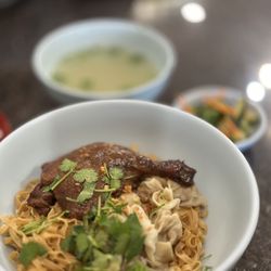 Thai Nghiep Ky Mi Gia - #7 Hoành Thánh Mì Vịt Tìem - braised duck leg, wontons & wide egg noodles w/broth & quick pickles on the side $15