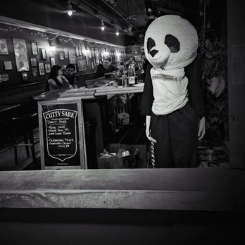 Doc's Clock - Drinking tuxedos for sale as modeled by this very normal panda lady - Dive Bars Near Me - San Francisco, California