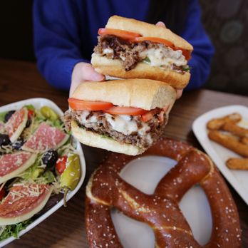 Ledo Pizza - a person holding a sandwich over a salad and pretzels - Pizza Near Me - Washington, DC, District of Columbia Ledo Pizza - a person holding a sandwich over a salad and pretzels - Pizza Near Me - Washington, DC, District of Columbia