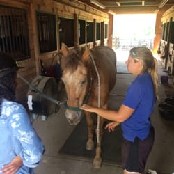 Brentsville Stables - Instructor teaching safety and cleaning the horse.