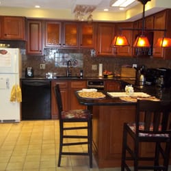 Kitchen Tune-Up - A warm and inviting cherry wood look with tinted glass doors, granite countertops and pendant lighting.