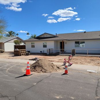 Acosta Plastering - A residential house is under construction, with construction cones, a pile of dirt, and a child's tricycle in front of the property. - Stucco Services Near Me - Gilbert, Arizona