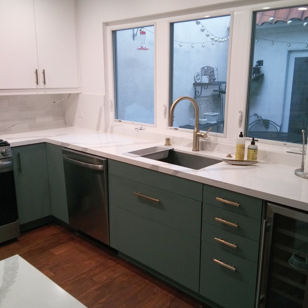 a kitchen with white counter tops and green cabinets a kitchen with white counter tops and green cabinets