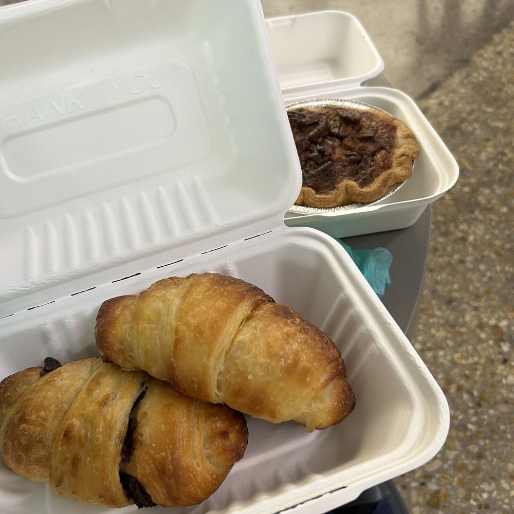 Lucy J's Bakery - Croissant and chocolate croissant in a recyclable container. And in the back a very delicious pecan pie! - Bakeries Near Me - Memphis, Tennessee Lucy J's Bakery - Croissant and chocolate croissant in a recyclable container. And in the back a very delicious pecan pie! - Bakeries Near Me - Memphis, Tennessee