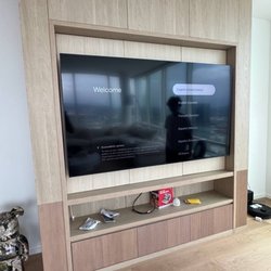 Grindlex Home Services - Sleek integration of a large display into a custom wood entertainment center.