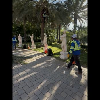 Off Czn Tree Experts - Our crew carefully trimming palm trees in a beautifully landscaped property. With detailed surroundings like stone pavers and statues, safet - Tree Services Near Me