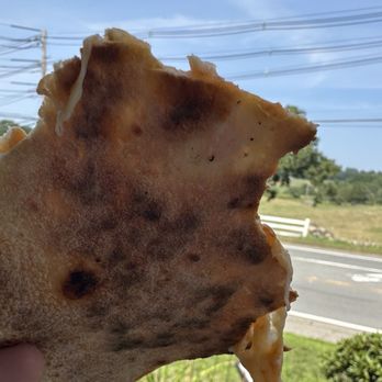 La Main - The underside of the crust. Soft interior, slightly crispy exterior. Minimal charring. Expect level oven mastery. - Pizza Near Me - Middleton, Massachusetts