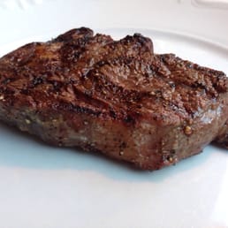 Dry aged rib eye of unknown size served all by itself on a plate (sides are served separately).