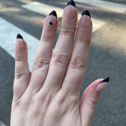 Gel X nails with black French tip and a heart detail on the ring finger Gel X nails with black French tip and a heart detail on the ring finger