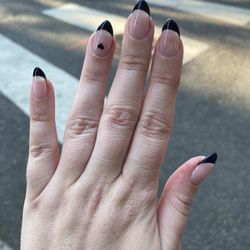 Oasis Foot Spa - Gel X nails with black French tip and a heart detail on the ring finger
