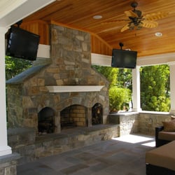 Land Art Associates - Inside view of an outdoor living area with masonry chimney, distressed wood ceiling, Azek trim work and metal seem roof.