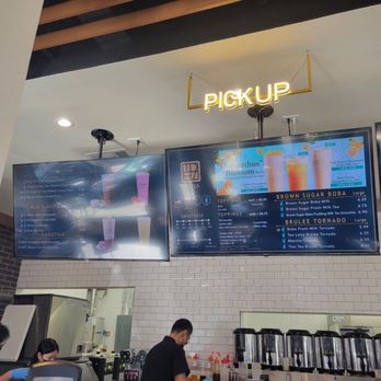TP Tea - Two digital menu screens show various bubble tea drinks and toppings at a bubble tea shop, with a pickup sign hanging above. - Bubble Tea Near Me - Millbrae, California