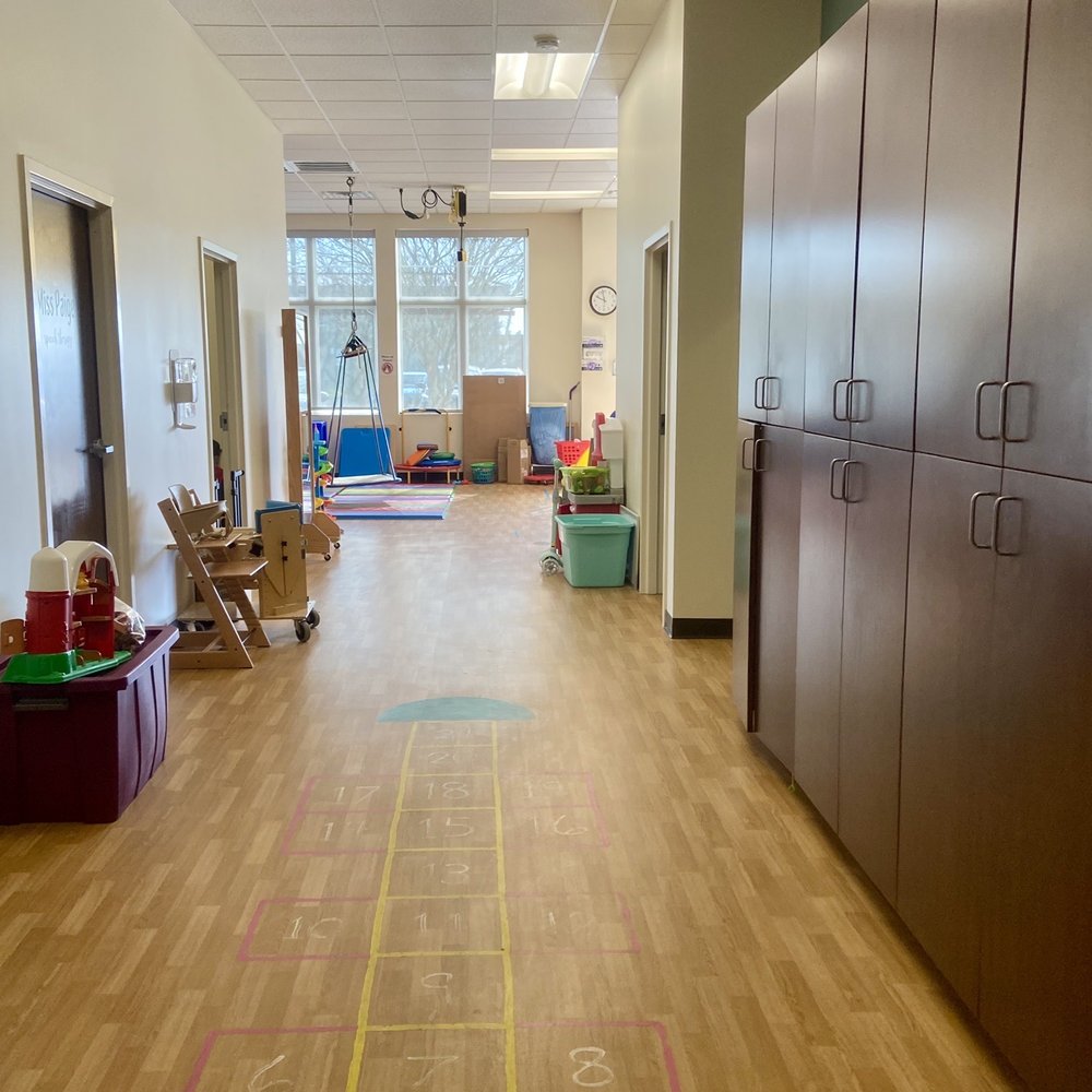 Sentara Therapy Center - Red Mill - Pediatric side: a row of therapists' offices on the left, storage cubbies on the right. - Physical Therapy Near Me - Virginia Beach, Virginia