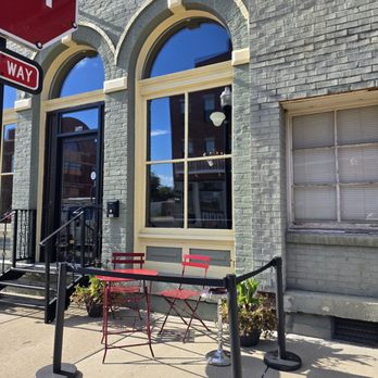 1838 Bourbon and Wine Bar - A table and chairs to the right of the door on the sidewalk. - Wine Bars Near Me - Rushville, Indiana