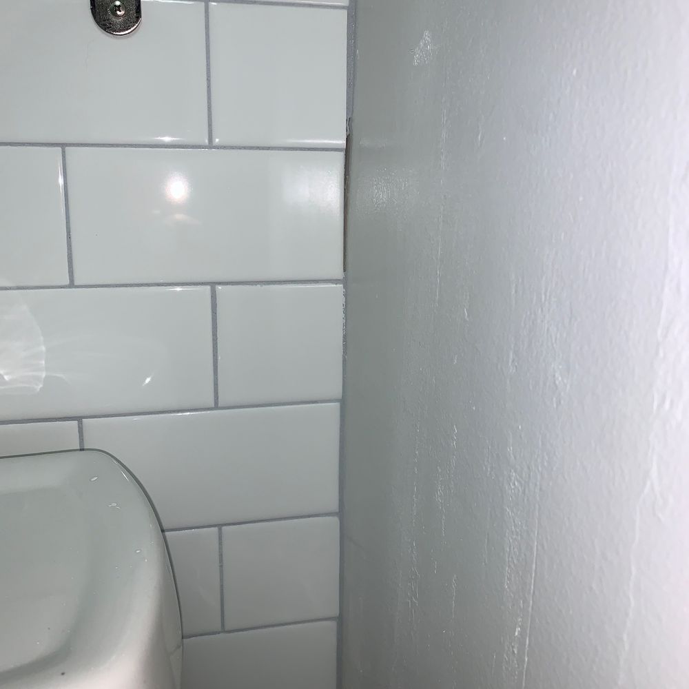 Grout not completed around the wall. Chunks missing, as they were cutting corners. Grout not completed around the wall. Chunks missing, as they were cutting corners.