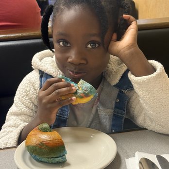 Rob's Bageland - This is baby girl, enjoying her rainbow bagel - Delis Near Me - Plantation, Florida