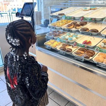 Krispy Kreme - a little girl standing in front of a display case of donuts - Donuts Near Me - Burlington, North Carolina Krispy Kreme - a little girl standing in front of a display case of donuts - Donuts Near Me - Burlington, North Carolina